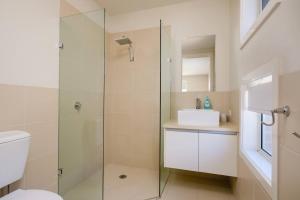 a bathroom with a glass shower and a sink at Splendour on Sackville in Albury +5 photos