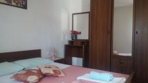 um quarto com uma cama com duas almofadas e um espelho em Apartments by the sea Rtina - Stosici, Zadar - 5883 em Rtina