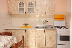 uma pequena cozinha com um lavatório e um fogão em Apartments by the sea Rtina - Stosici, Zadar - 5883 em Rtina