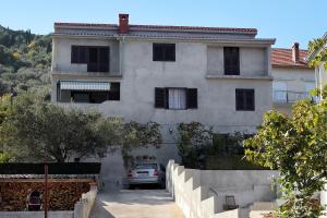 dom z samochodem zaparkowanym przed nim w obiekcie Apartments by the sea Kali, Ugljan - 5828 w mieście Kali