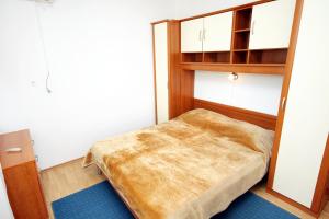 a small bedroom with a bed and a book shelf at Apartments by the sea Kali, Ugljan - 5828 in Kali