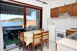 kuchnia ze stołem i widokiem na ocean w obiekcie Apartments by the sea Kali, Ugljan - 5828 w mieście Kali