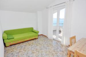 ein grünes Sofa im Wohnzimmer mit Fenster in der Unterkunft Apartments by the sea Bibinje, Zadar - 5916 in Bibinje