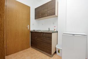 eine Küche mit einem Waschbecken und einer Holztür in der Unterkunft Apartments by the sea Bibinje, Zadar - 5916 in Bibinje