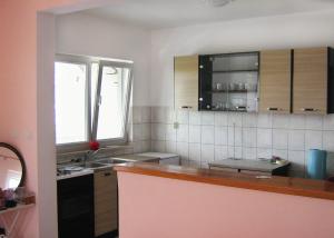 a kitchen with wooden cabinets and a counter top at Apartments by the sea Kneza, Korcula - 4342 in Račišće