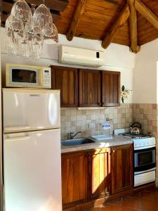 a kitchen with a white refrigerator and wooden cabinets at TOLHUIN COLON in Colón