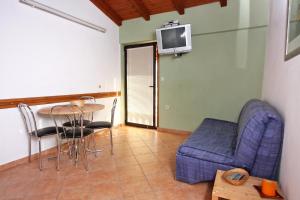 a living room with a blue couch and a table at Apartments with a parking space Bibinje, Zadar - 5732 in Bibinje