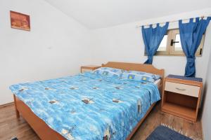 1 dormitorio con 1 cama con sábanas azules y cortinas azules en Apartments by the sea Bibinje, Zadar - 5769 en Bibinje