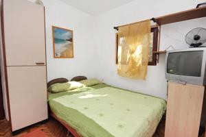 1 dormitorio pequeño con 1 cama y TV en Apartments by the sea Bibinje, Zadar - 5769 en Bibinje