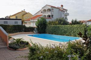 a swimming pool in front of a house at Apartment Zadar - Diklo 5774d in Zadar