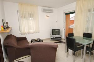 een woonkamer met een bank, een tafel en een televisie bij Apartment Zadar - Diklo 5774d in Zadar