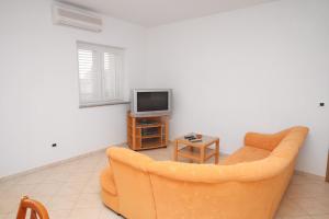- un salon avec un canapé et une télévision dans l'établissement Apartments by the sea Vrsi - Mulo, Zadar - 5860, à Nin
