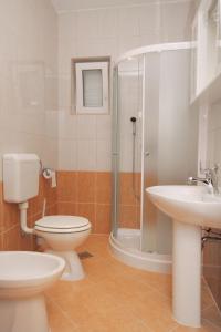 La salle de bains est pourvue de toilettes, d'un lavabo et d'une douche. dans l'établissement Apartments by the sea Vrsi - Mulo, Zadar - 5860, à Nin
