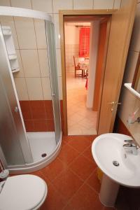a bathroom with a shower and a toilet and a sink at Apartments by the sea Vrsi - Mulo, Zadar - 5860 in Nin