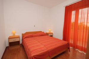 - une chambre avec un lit doté de draps orange et une fenêtre dans l'établissement Apartments by the sea Vrsi - Mulo, Zadar - 5860, à Nin