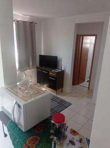 a living room with a microwave and wine glasses on a table at Aluguel Agua Marinha in Campos dos Goytacazes +6 photos