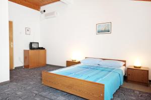 ein Schlafzimmer mit einem großen Bett mit blauer Bettwäsche in der Unterkunft Apartments with a parking space Vrsi - Mulo, Zadar - 5796 in Vrsi