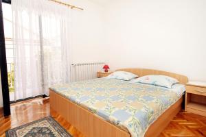 ein Schlafzimmer mit einem Bett und einem großen Fenster in der Unterkunft Apartments with a parking space Sukosan, Zadar - 5888 in Sukošan