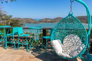 a swing with chairs and tables on a patio at Royal Turquesa Boutique Hotel in Búzios