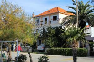 een man die voor een huis loopt bij Apartments by the sea Zadar - Diklo, Zadar - 5911 in Zadar