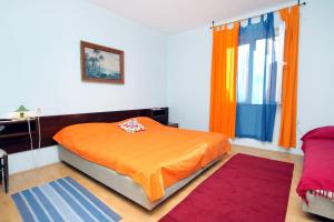 een slaapkamer met een oranje bed en een raam bij Apartments by the sea Zadar - Diklo, Zadar - 5911 in Zadar