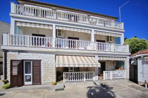 ein großes weißes Gebäude mit Balkon in der Unterkunft Apartments and rooms by the sea Zadar - 5874 in Zadar