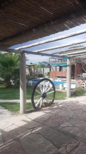 a wagon wheel is sitting under a building at Cabañas Lugar Escondido in Mendoza
