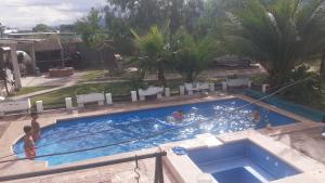 an overhead view of a swimming pool with people in it at Cabañas Lugar Escondido in Mendoza