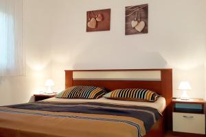 a bedroom with a bed with two lamps and hearts on the wall at Apartments by the sea Vrsi - Mulo, Zadar - 5859 in Vrsi