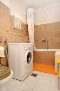 łazienka z pralką i wanną w obiekcie Apartments and rooms with parking space Korcula - 4399 w Korčuli