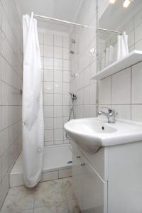 a white bathroom with a sink and a shower at Apartments and rooms with parking space Korcula - 4399 in Korčula