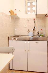 eine kleine Küche mit weißen Schränken und einem Waschbecken in der Unterkunft Apartments by the sea Trstenik, Peljesac - 4570 in Trstenik