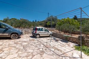 a small car parked next to a stone wall at Apartments by the sea Cove Pokrivenik, Hvar - 4604 in Gdinj