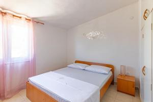 a bedroom with a bed with white sheets and a window at Apartments by the sea Cove Pokrivenik, Hvar - 4604 in Gdinj