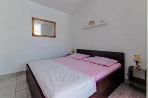a bedroom with a bed with pink sheets and a mirror at Apartments by the sea Cove Pokrivenik, Hvar - 4604 in Gdinj