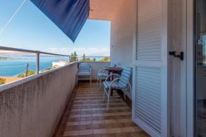 a balcony with a table and chairs and the ocean at Apartments by the sea Cove Pokrivenik, Hvar - 4604 in Gdinj