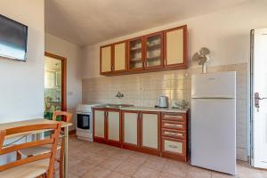 a kitchen with a white refrigerator and a table at Apartments by the sea Cove Pokrivenik, Hvar - 4604 in Gdinj