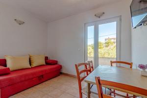 a living room with a red couch and a table at Apartments by the sea Cove Pokrivenik, Hvar - 4604 in Gdinj