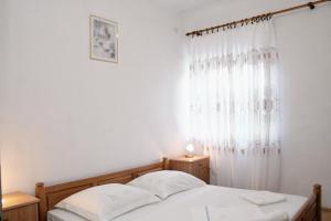 a bedroom with a bed and a window with curtains at Apartments by the sea Lumbarda, Korcula - 4358 in Lumbarda