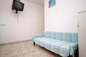 a room with a couch and a tv on the wall at Apartments by the sea Lumbarda, Korcula - 4358 in Lumbarda