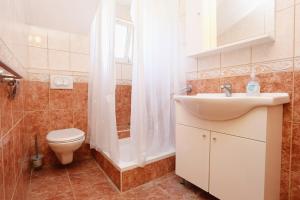 a bathroom with a toilet and a sink and a shower at Studio Zuljana 4576c in Žuljana
