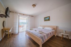 a bedroom with a large bed and a balcony at Apartment Lumbarda 4446b in Lumbarda