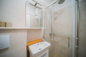 a white bathroom with a shower and a sink at Apartment Lumbarda 4446b in Lumbarda