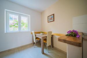 a kitchen with a table and chairs and a window at Apartment Lumbarda 4446b in Lumbarda
