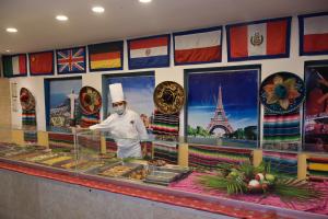a chef standing in front of a counter with food at Ritz Acapulco All Inclusive in Acapulco