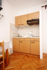 a kitchen with wooden cabinets and a wooden floor at Apartment Orebic 4525c in Orebić