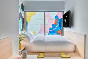 a bedroom with a white bed and a large window at lyf Collingwood Melbourne in Melbourne