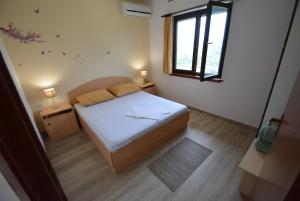 a small bedroom with a bed and a window at Apartments by the sea Kozino, Zadar - 5893 in Kožino