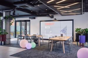 a conference room with tables and chairs and a projection screen at lyf Collingwood Melbourne in Melbourne