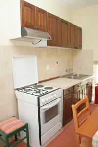 a kitchen with a white stove and a sink at Family friendly seaside apartments Orebic, Peljesac - 4537 in Orebić